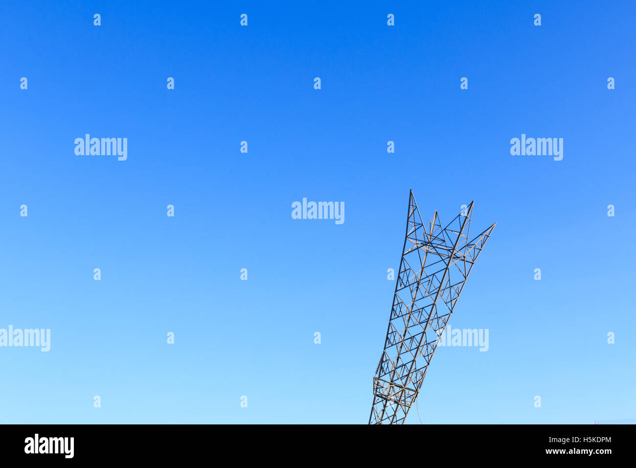 Capovolto elettricità pilone a Greenwich, Londra contro un blu cielo privo di nuvole Foto Stock