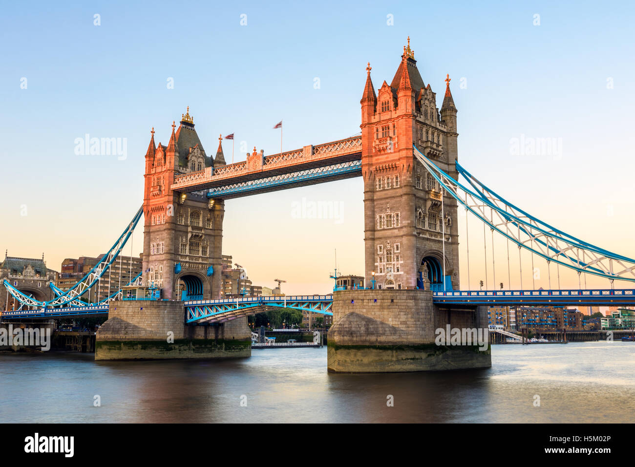 Il Tower Bridge di Londra al tramonto, colata di una luce arancione sulla parte del bridge Foto Stock