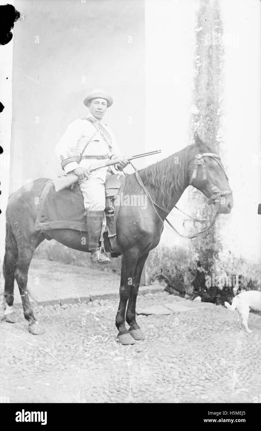 Un soldato armato a cavallo durante la rivoluzione messicana, simboleggiando il conflitto militare tra le forze rivoluzionarie e le truppe governative. L'immagine rappresenta il ruolo dei soldati e delle armi da fuoco negli eventi della rivoluzione. Foto Stock