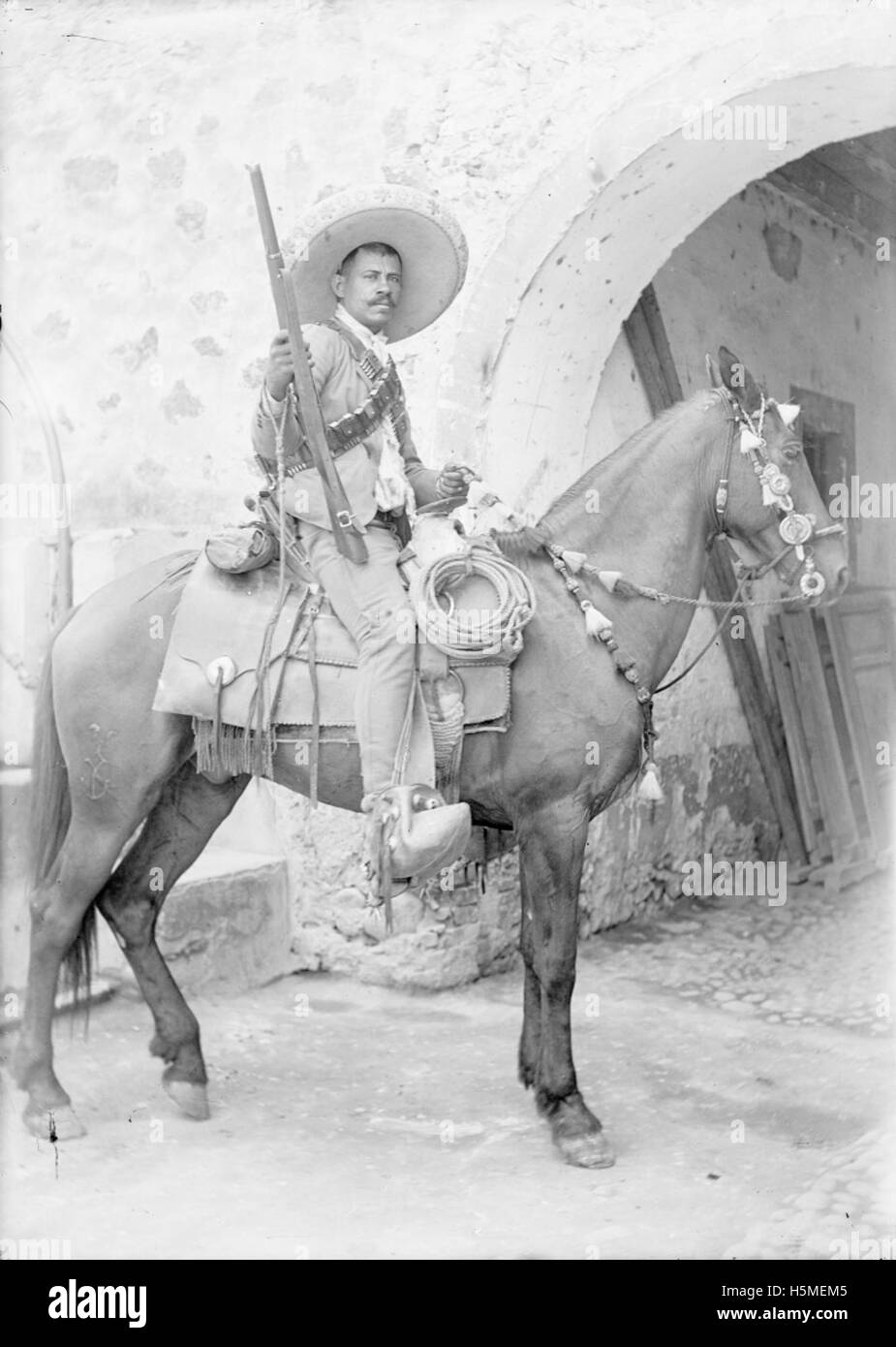 Un'immagine che probabilmente raffigura Coronel Amador Salazar durante la rivoluzione messicana, probabilmente con soldati e cavalli. L'attenzione sembra essere concentrata sulle armi da fuoco e sul personale militare, mostrando la cultura militare dell'epoca. Foto Stock