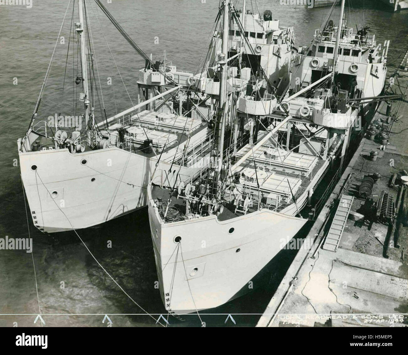 Questa immagine cattura le petroliere costruite per gli sbarchi in Normandia nel 1944, evidenziando gli sforzi dei costruttori navali britannici, come John Readhead & Sons. I carri armati facevano parte delle attrezzature del D-Day costruite in cantieri navali come High West Yard, che mostravano la costruzione marittima dell'era della seconda guerra mondiale. L'immagine mostra i dettagli della nave, tra cui lo scafo, il ponte e gli oblò della nave, sullo sfondo della costruzione navale industriale durante la guerra. Foto Stock
