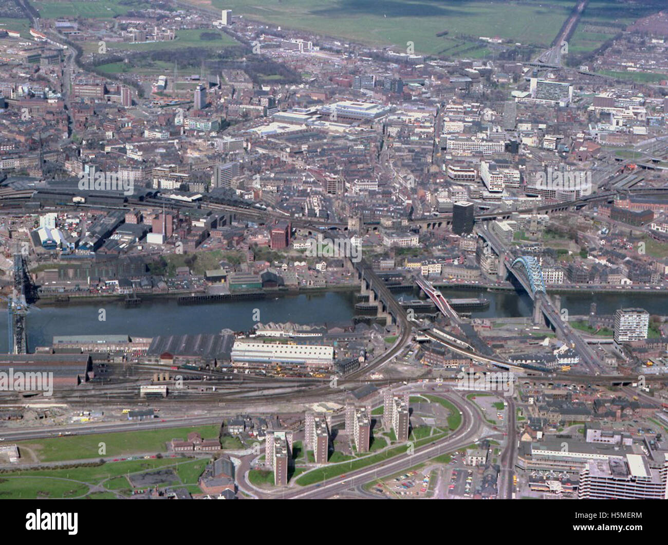 Questa fotografia aerea del 1978 cattura diversi ponti iconici sul fiume Tyne, tra cui il Tyne Bridge e High Level Bridge, insieme al Quayside e alle aree circostanti. L'immagine offre una vivida istantanea del paesaggio industriale e architettonico di Newcastle upon Tyne, che mostra sia lo sviluppo della città che il suo patrimonio in termini di trasporti e infrastrutture. Foto Stock