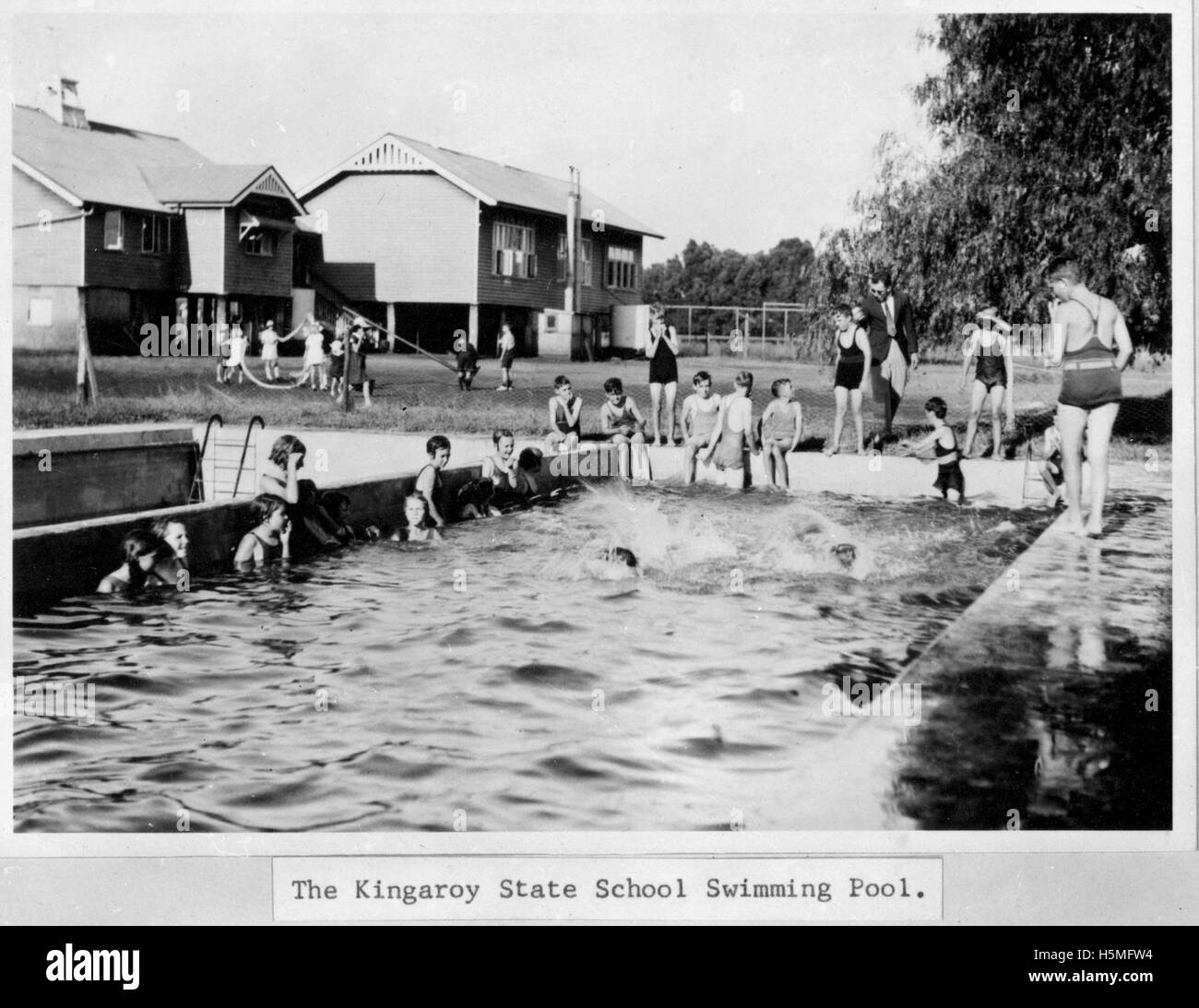Un gruppo di scolari si diverte nella piscina della Kingaroy State School. L'immagine cattura un momento di gioia giovanile e di vita scolastica nella città australiana di Kingaroy. Foto Stock Un gruppo di scolari si diverte nella piscina della Kingaroy State School. L'immagine cattura un momento di gioia giovanile e di vita scolastica nella città australiana di Kingaroy. Foto Stock