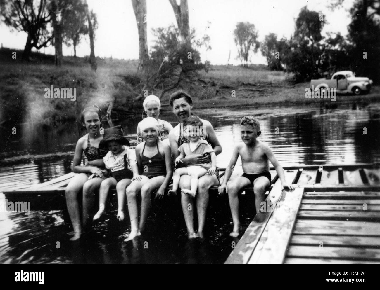Una famiglia è ritratta nei costumi da bagno presso la piscina di Callide Creek, probabilmente godendosi una giornata estiva. La fotografia cattura un momento di svago e di legame con la famiglia durante le attività ricreative all'aperto. Foto Stock
