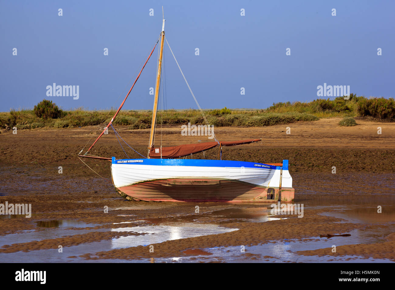 Barca che riposa sulla chiglia a bassa marea a Burnham-Overy-Staithe sulla costa di Norfolk, Inghilterra, Regno Unito Foto Stock