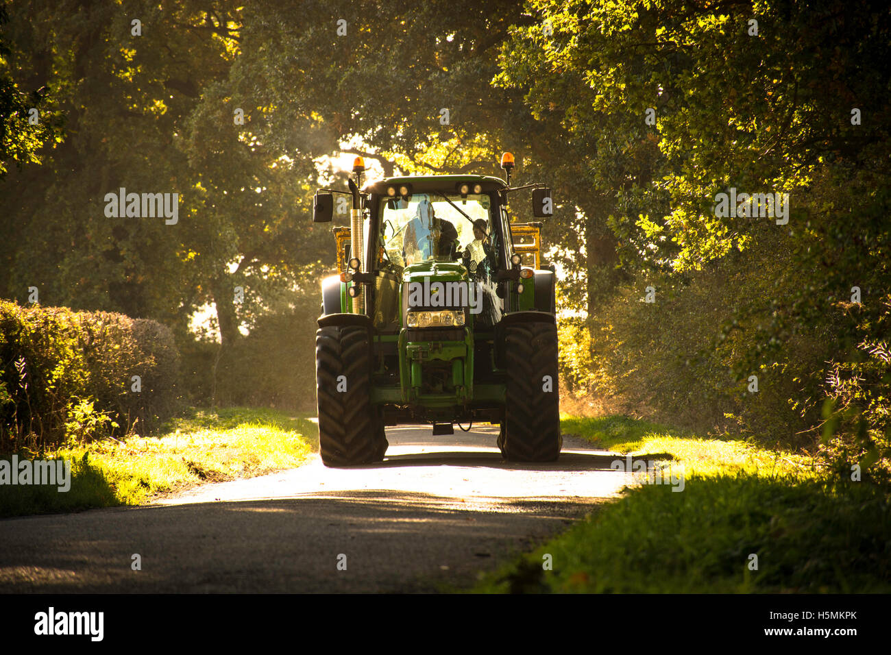 Un trattore John Deere assordanti lungo una strada di campagna Foto Stock