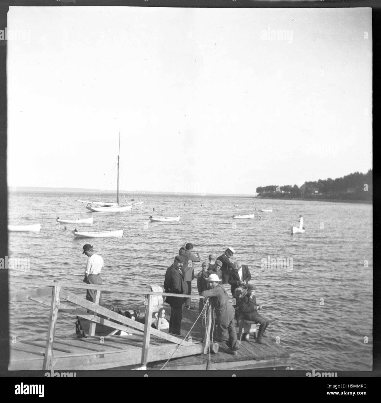 Questa fotografia dell'agosto 1900 mostra gli individui che pescano a Northport, catturando un momento nella vita quotidiana della comunità. L'immagine evidenzia l'importanza della pesca come mezzo di sussistenza all'inizio del XX secolo. Foto Stock