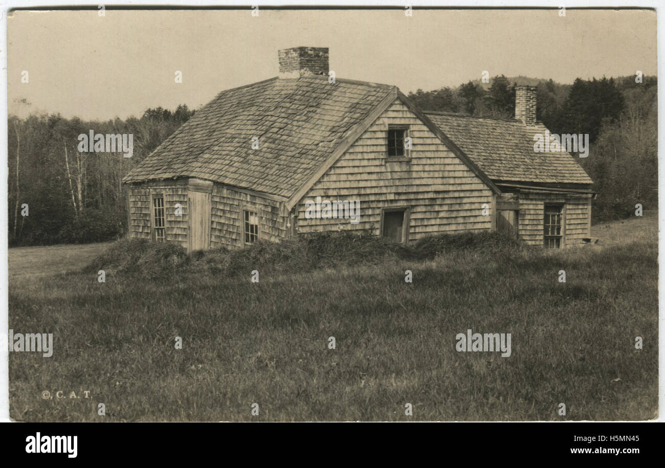 Una vista di un vecchio capo casa di stile sul Camden Road a Belfast, Maine. La casa del tetto è la colatura, ed erba è accumulata intorno alla base dell'edificio. Foto Stock