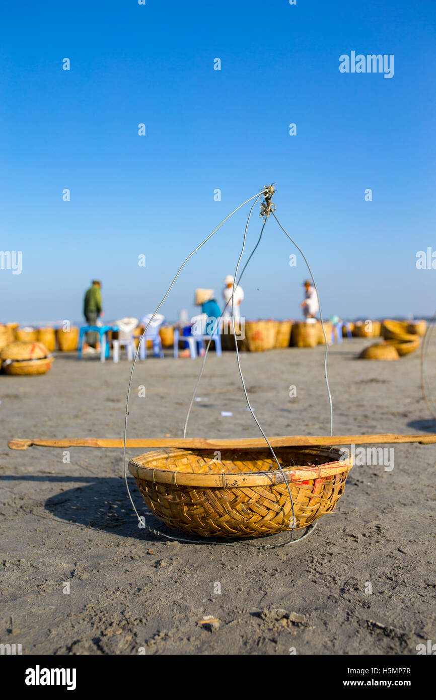 Cestello di pesca con due donna, indossare un cappello conico in background sotto il cielo blu a lungo hai beach, Ba Ria, Vung Tau, Vietnam Foto Stock