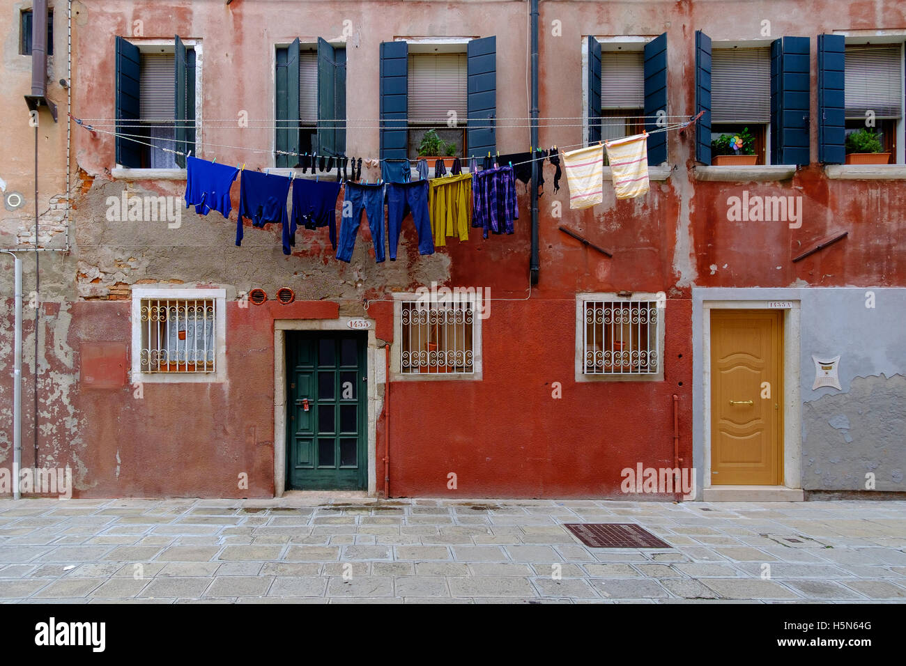 Vestiti appesi ad asciugare in Venezia, al di fuori di un vecchio edificio rosso Foto Stock