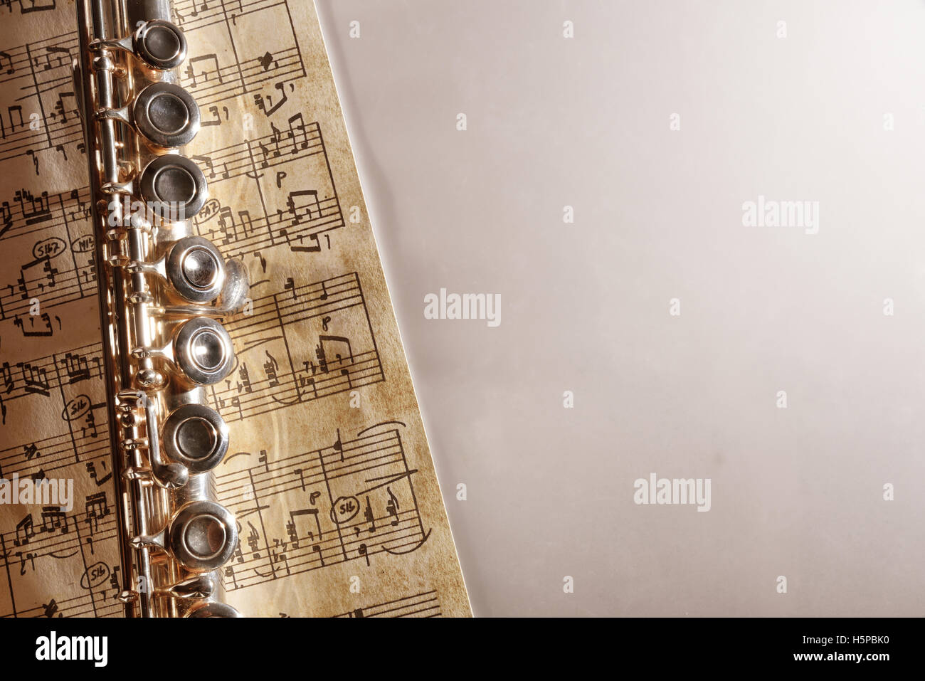 Flauto e manoscritti di musica del foglio sul tavolo bianco. Composizione orizzontale. Vista superiore Foto Stock