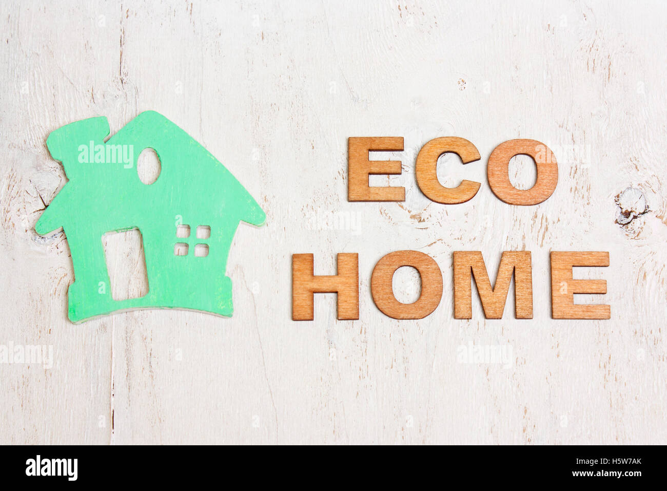Parola eco casa fatta di lettere in legno e una casa verde su sfondo bianco in legno antico Foto Stock