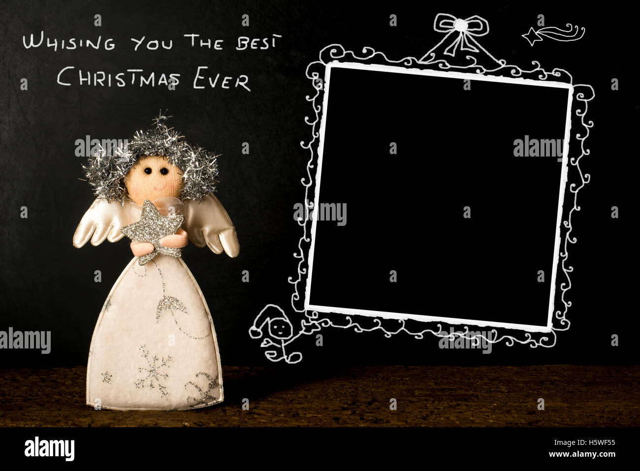 Funny photo frame di Natale carta, Angelo e vuoto cornice immagine disegnata a mano su una lavagna con il messaggio Scheda di Natale Foto Stock