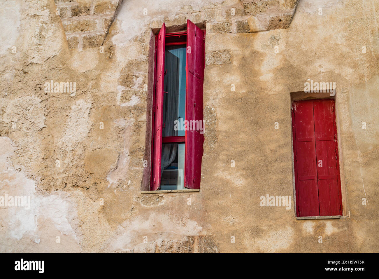 Finestre con persiane rosse in antica casa in Italia Foto Stock