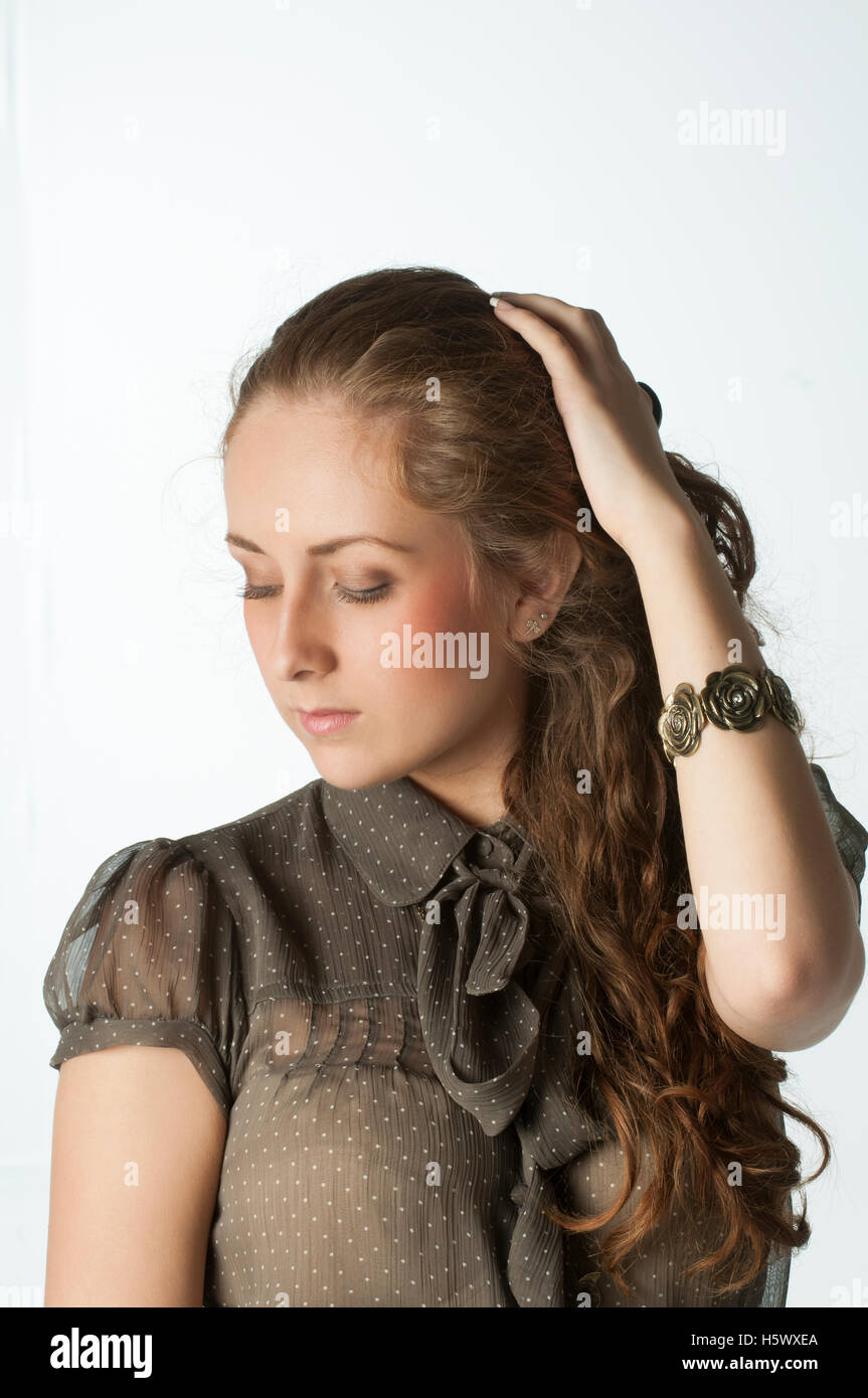 Giovane donna caucasica mano sulla testa guardando verso il basso Foto Stock