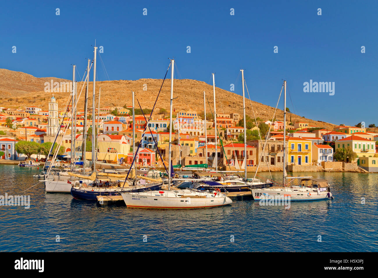 Yacht posti barca presso la città di Chalki, isola greca di Chalki situate al largo della costa nord di RODI, DODECANNESO Isola Gruppo, Grecia. Foto Stock