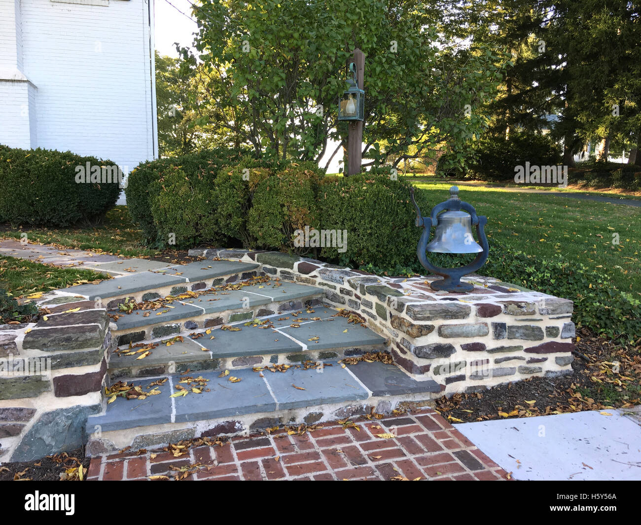 In lastricato fasi di curvatura e la parete in un giardino esterno Foto Stock