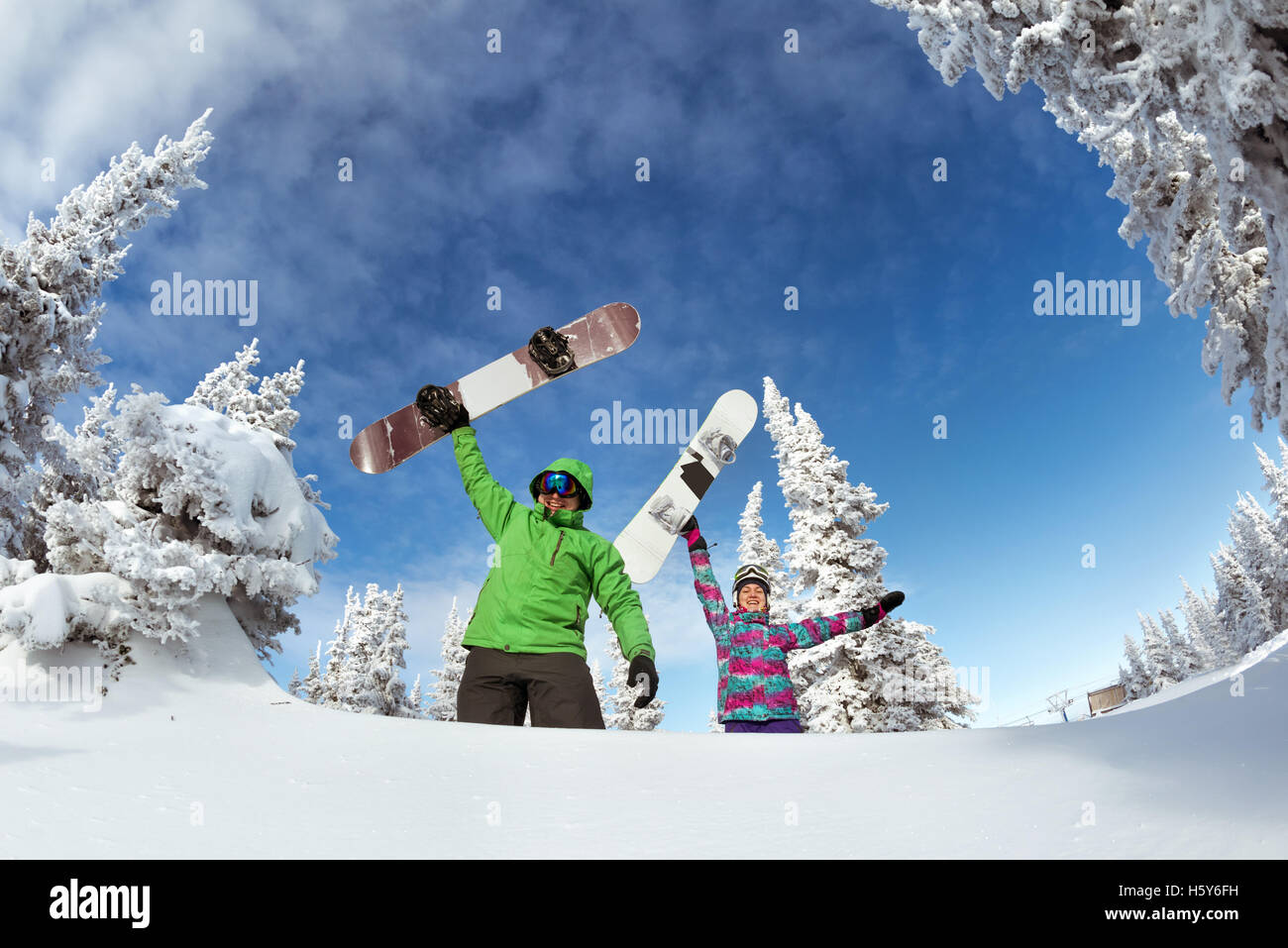Gli appassionati di snowboard in posa sul cielo blu sullo sfondo di montagne Foto Stock