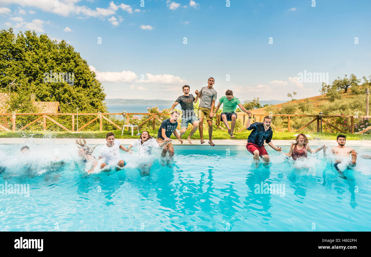 Un gruppo di ragazzi, adolescenti il salto in piscina, Lazio, Italia Foto Stock