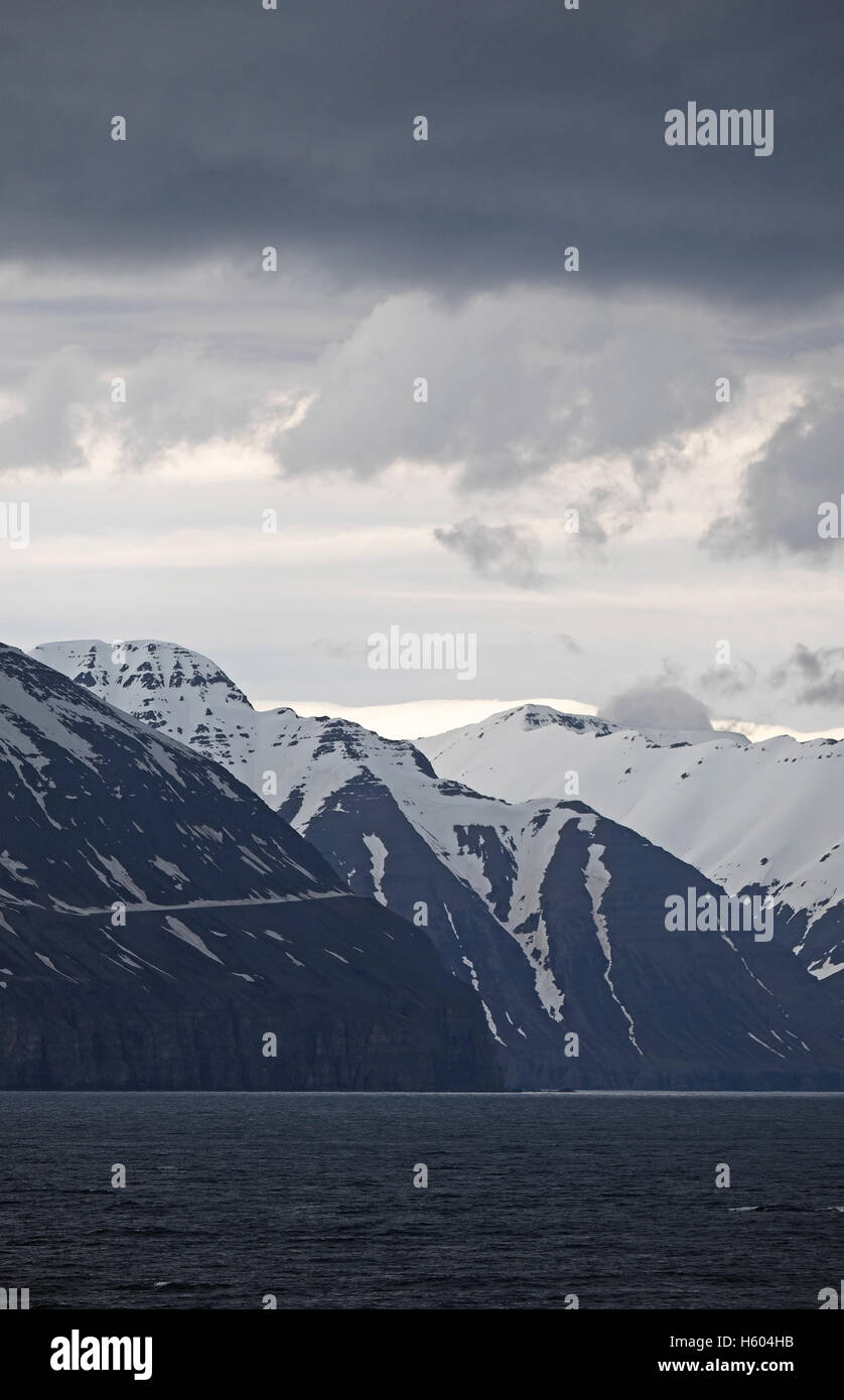 Montagne coperte di neve visto oltre Eyjafjordur, a nord di Akuretri, Islanda. Foto Stock