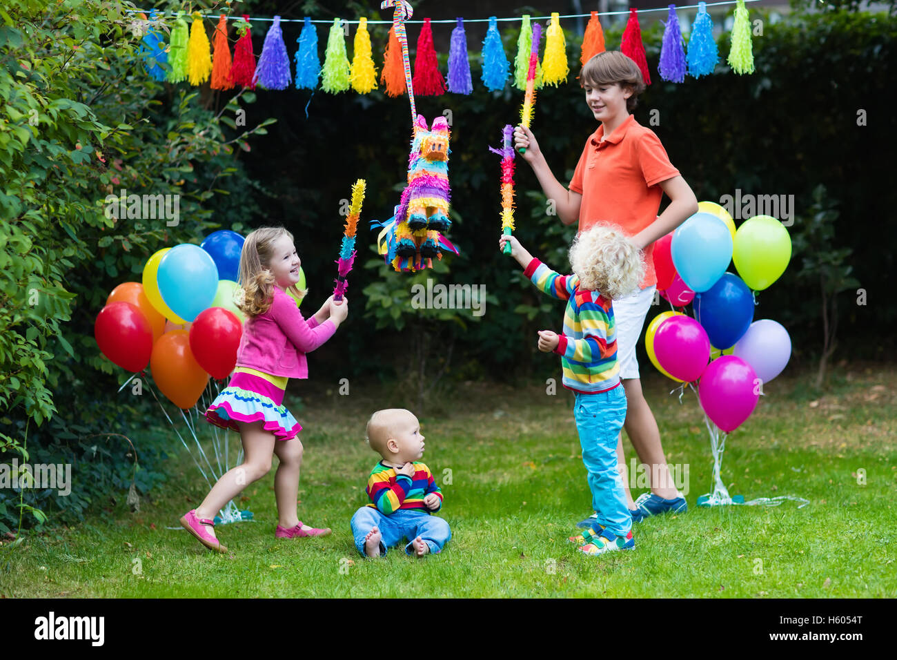 Kids festa di compleanno. Gruppo di bambini colpendo pinata e giocare con i  palloncini. La famiglia e gli amici festeggia il compleanno all'aperto Foto  stock - Alamy