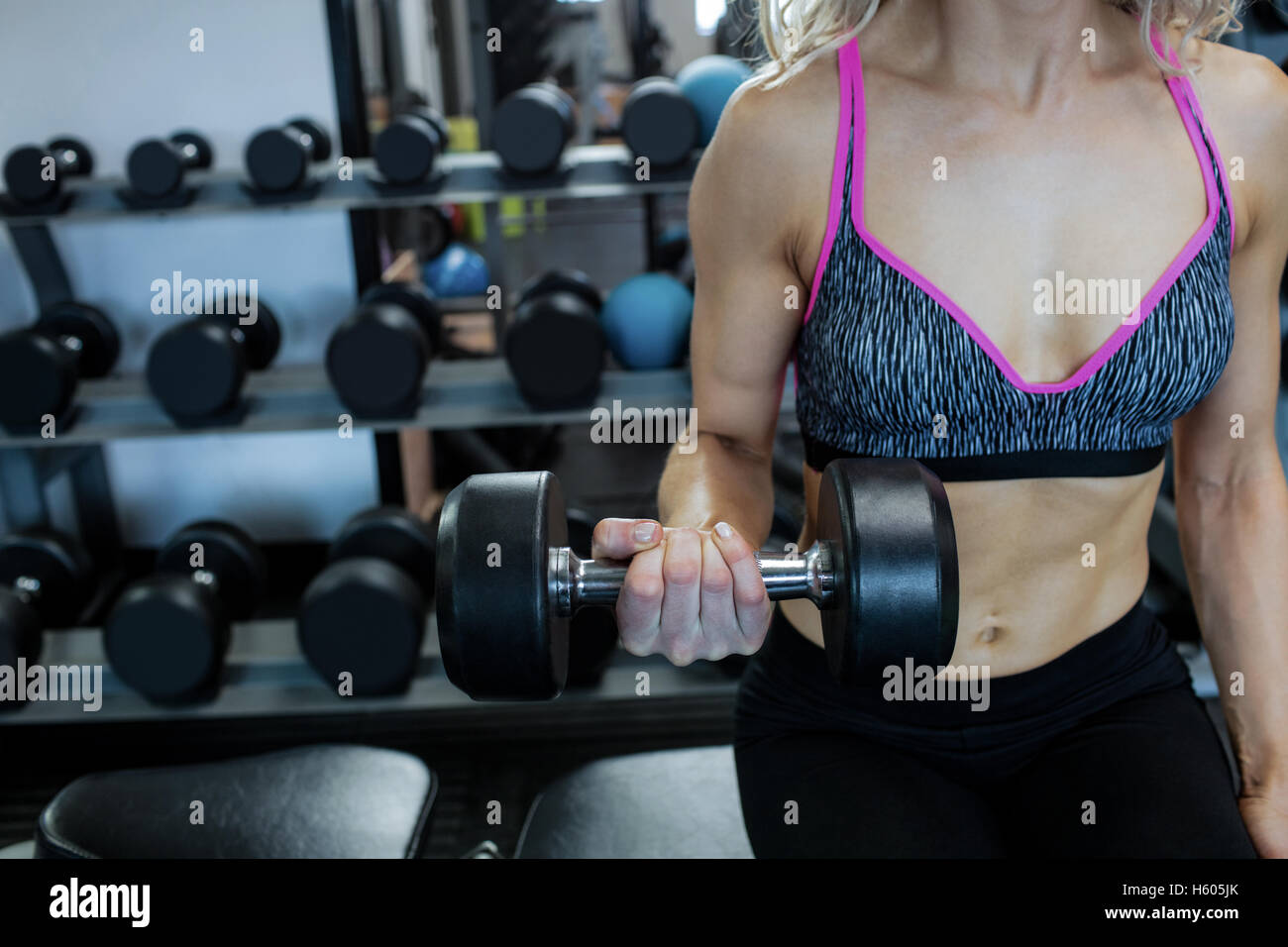 La donna il sollevamento pesi in palestra Foto Stock