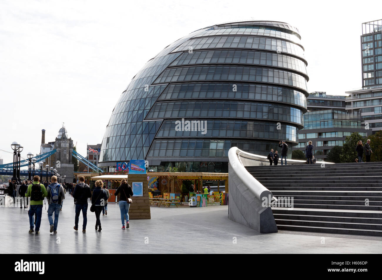 La gente camminare lungo la riva sud dal Municipio di Londra, Regno Unito Foto Stock