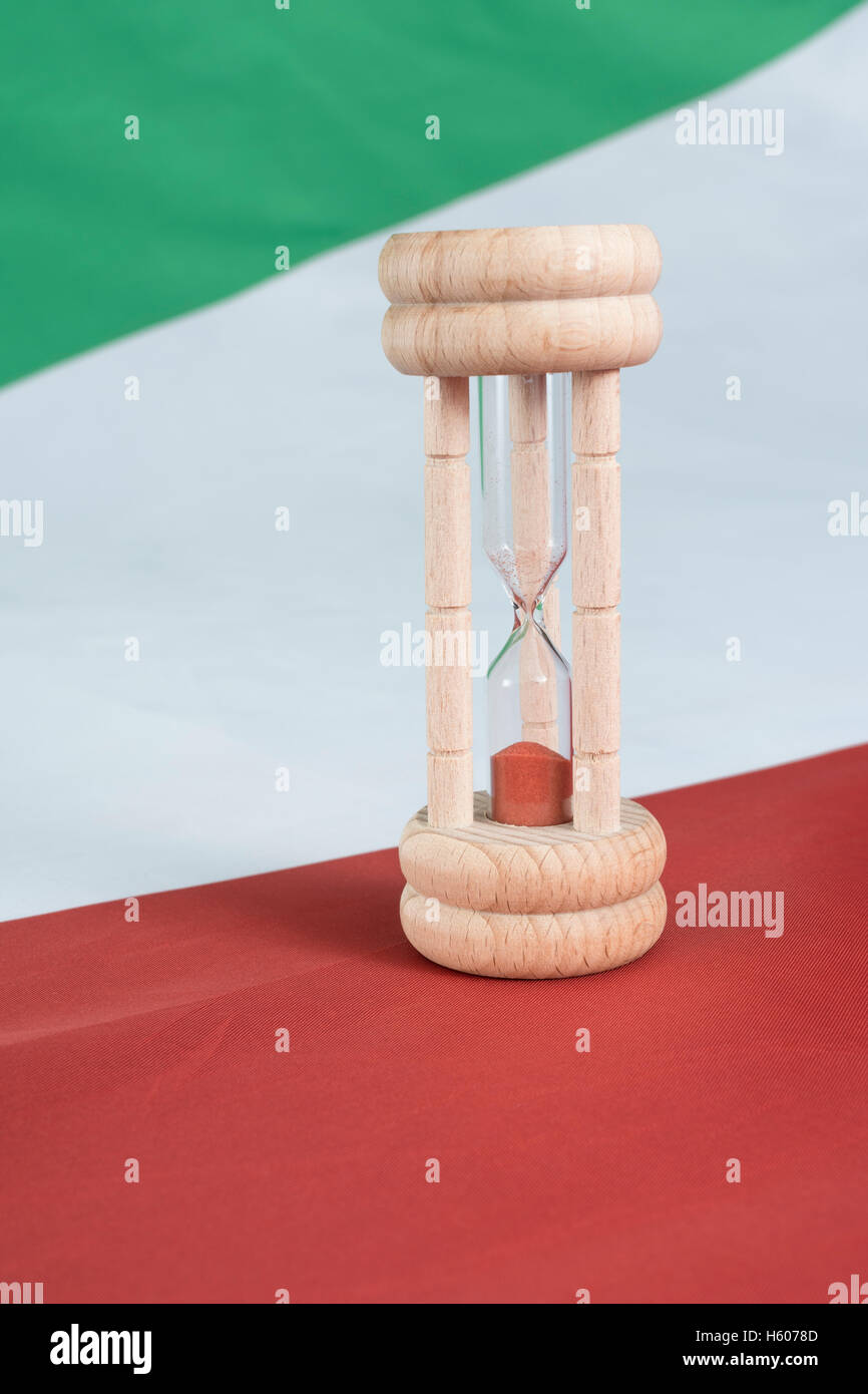 Uovo di legno timer set contro una bandiera italiana - una metafora visiva per il tempo di esecuzione per le banche italiane e il sistema finanziario + debito sovrano crisi. Foto Stock