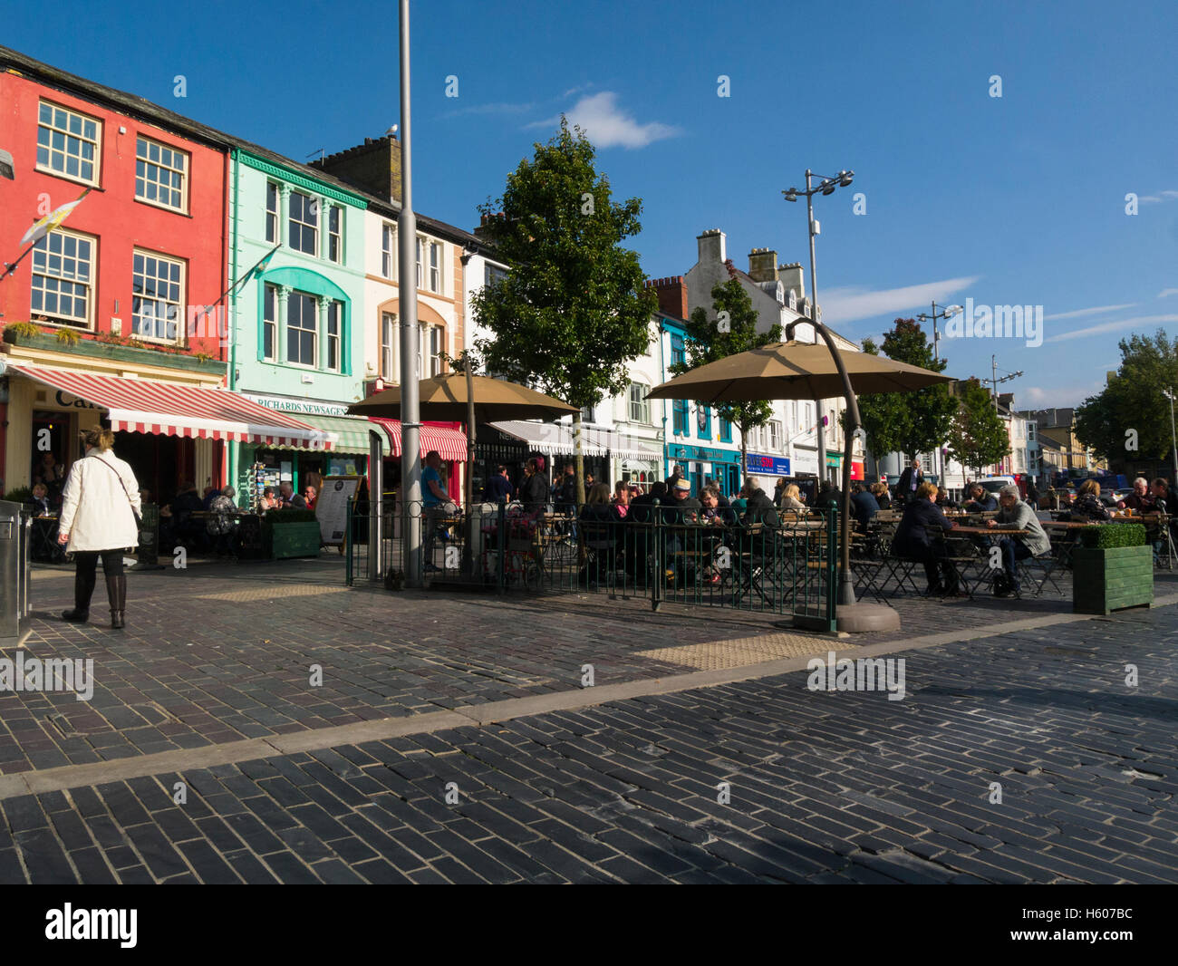 I visitatori per cenare fuori sulla bella giornata autunnale a Caernarfon Castle Square Gwynedd North Wales Caernarfon è città reale di comunità e porta sullo Stretto di Menai Foto Stock