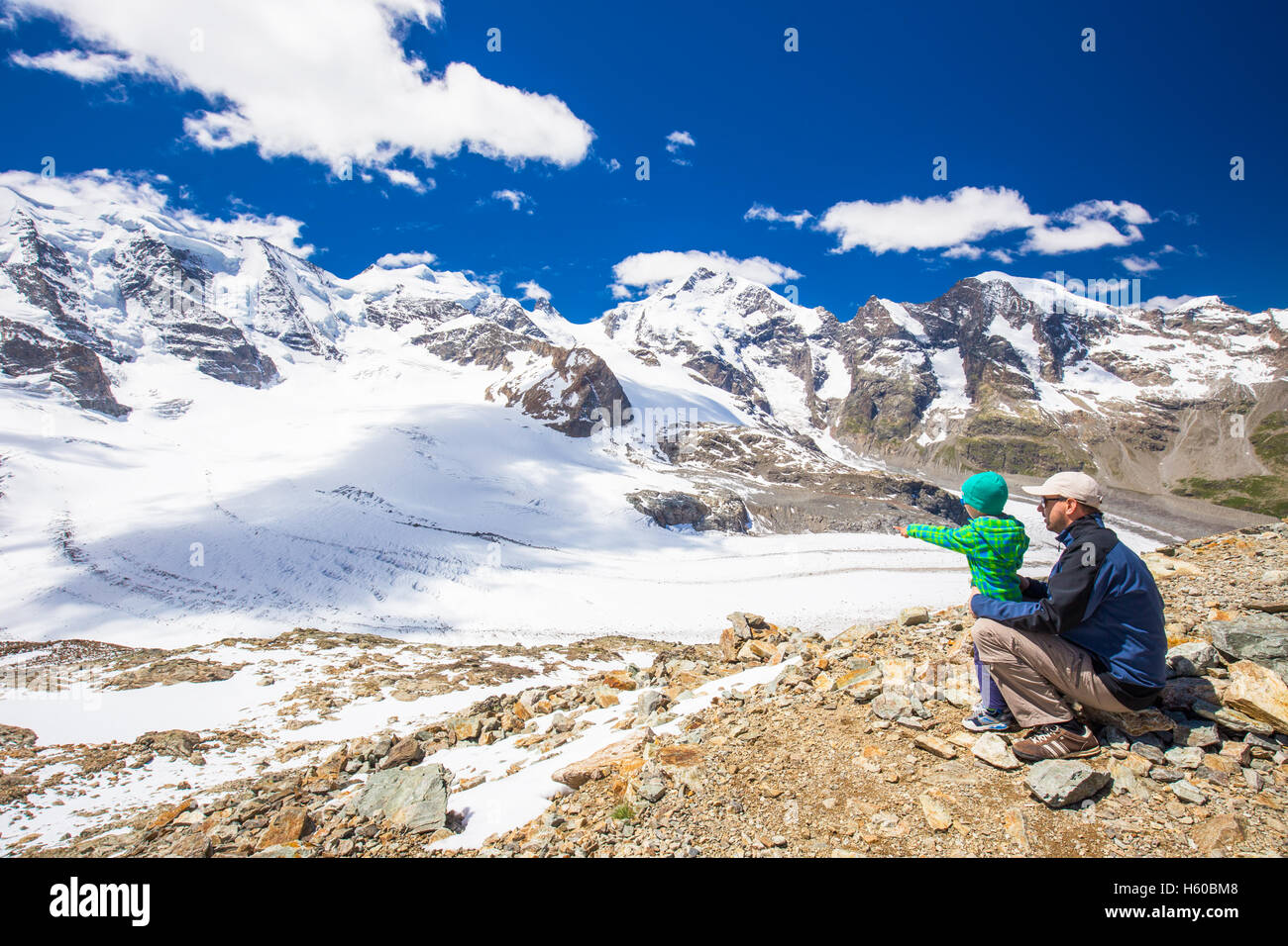 Padre abbraccia il suo piccolo figlio puntando al ghiacciaio di Morteratsch dal Diavolezza vicino a Sankt Moritz, Svizzera Foto Stock