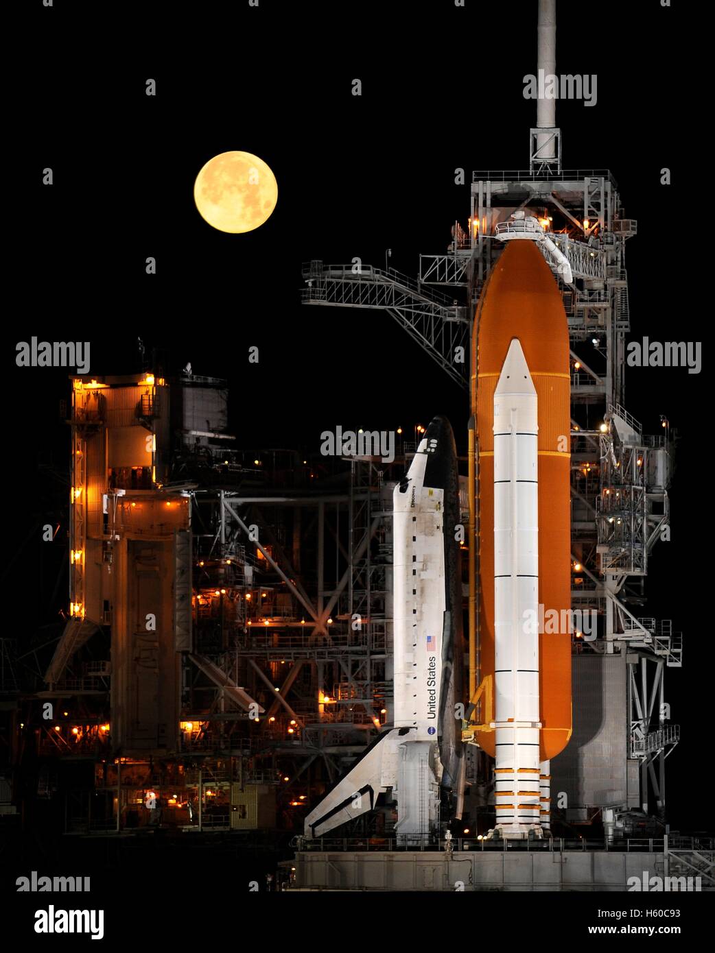 Una luna piena set nel cielo notturno come NASA Space Shuttle Discovery si siede in cima al Kennedy Space Center Launch Pad 39A in preparazione per STS-110 lancio della Missione alla Stazione Spaziale Internazionale Marzo 11, 2009 a Cape Canaveral, in Florida. Foto Stock