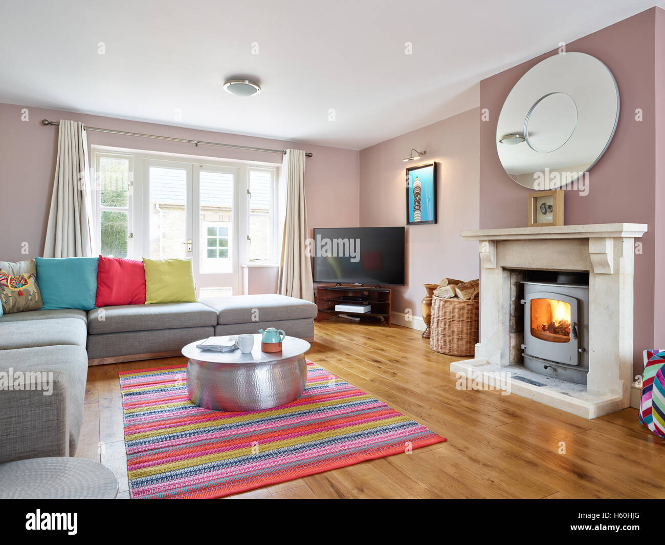 Un moderno e fresco colorato soggiorno con camino vittoriano & uno scoppiettante fuoco in un woodburner Foto Stock