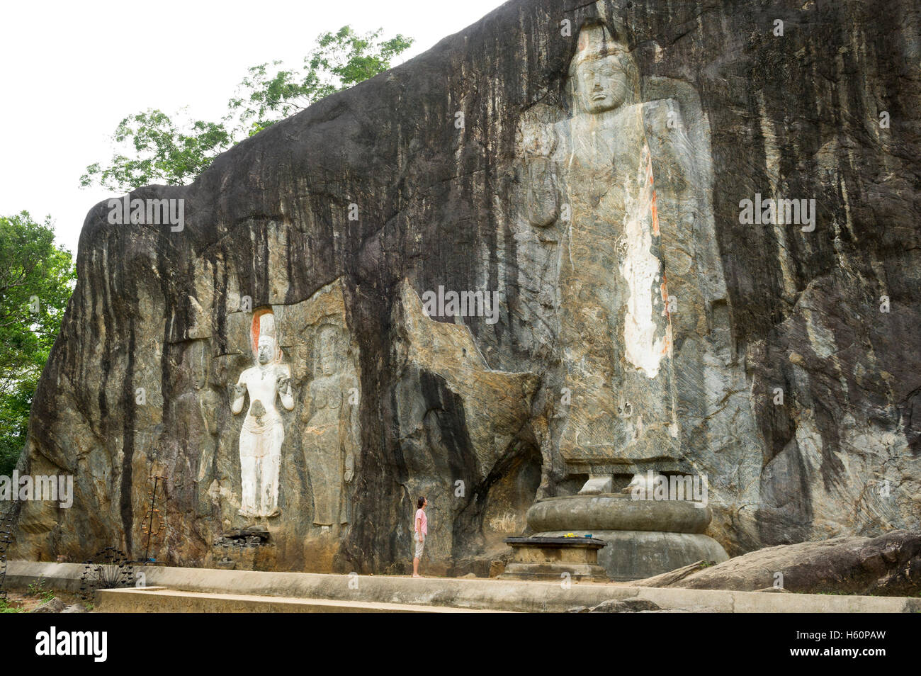 Tourist guardando le incisioni rupestri di Buduruwagala tempio buddista, decimo secolo, vicino Wellaweya, Sri Lanka Foto Stock