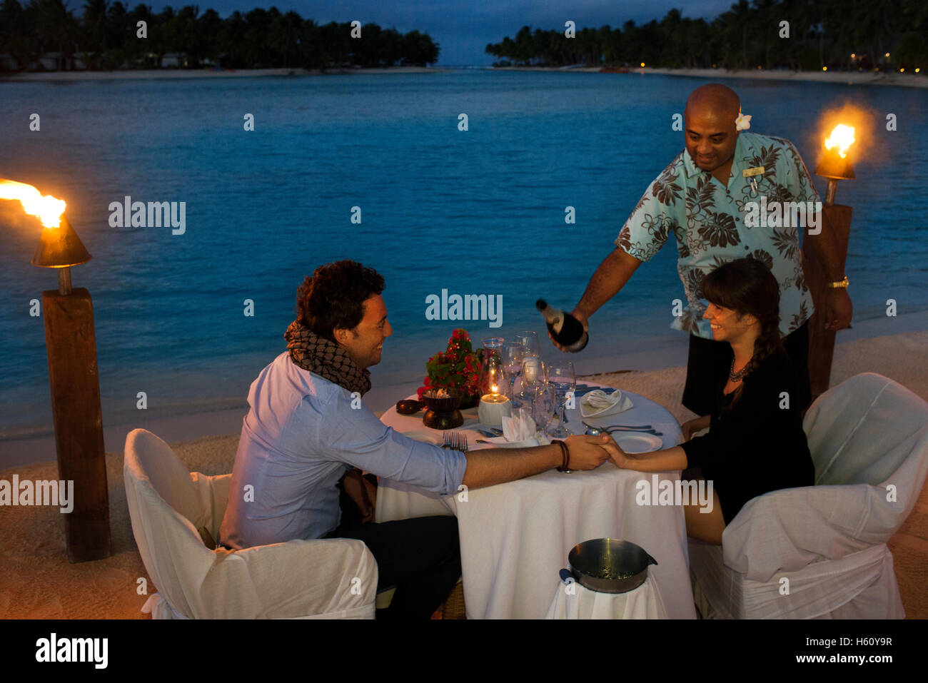 Aitutaki. Isole Cook. Polinesia. Oceano Pacifico del sud. Un giovane gode di una cena romantica in spiaggia in Aitutaki Lagoon Resort Foto Stock