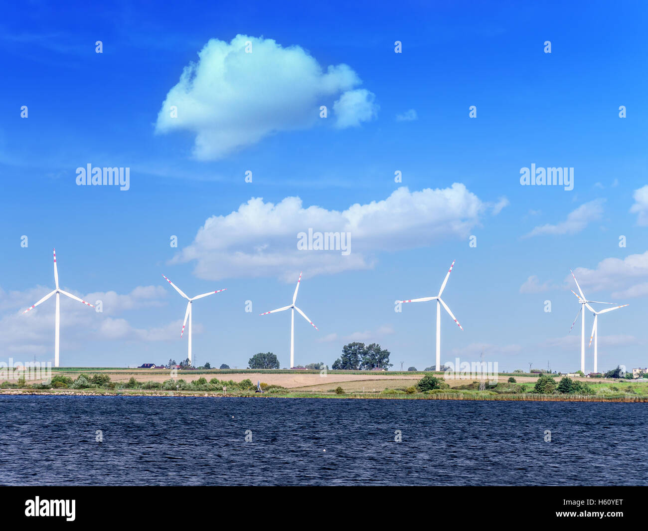 Fila di vento generatori di potenza contro il cielo blu Foto Stock