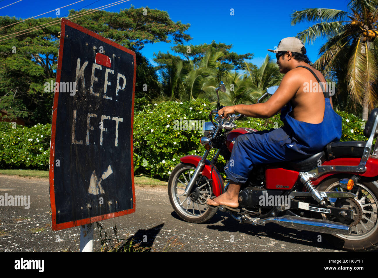 Atiu Island. Isole Cook. Polinesia. Oceano Pacifico del sud. Un abitante di Atiu guida con la sua moto per le strade dell'isola Foto Stock