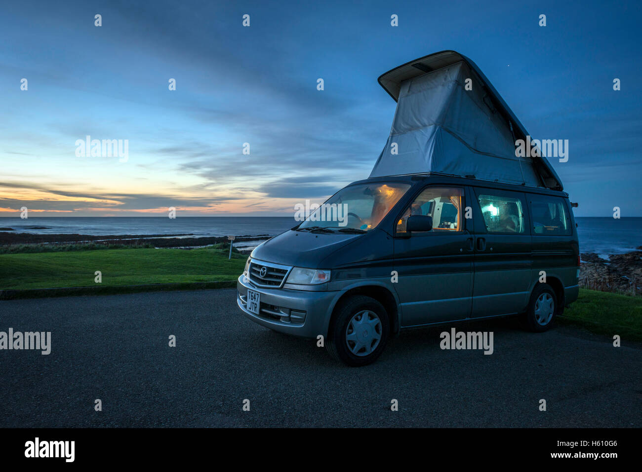 Mazda Bongo camper con pop up roof camping vicino al mare sulla terraferma e Isole Orcadi Scozia, Regno Unito Foto Stock