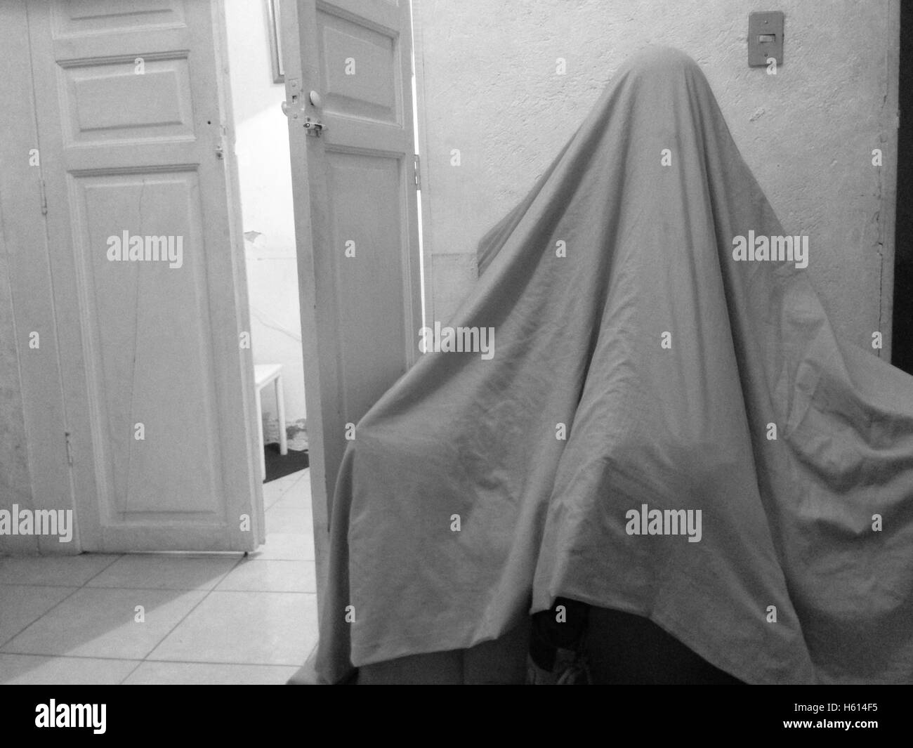 Ragazza in foglio guardando come Ghost Foto Stock