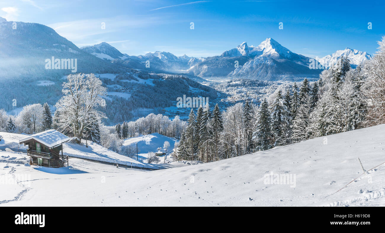 Bella bianca invernale del paesaggio di montagna delle Alpi con tradizionale baita in legno in una fredda giornata di sole con cielo blu Foto Stock