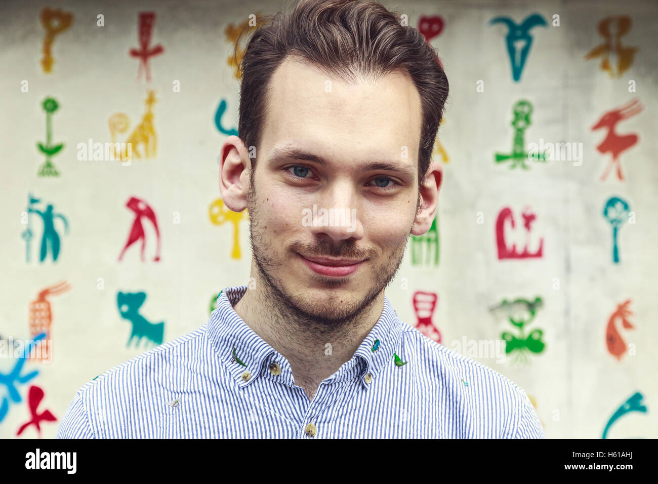 Ritratto di un giovane gentile uomo di fronte a un colorato sfondo funky Foto Stock