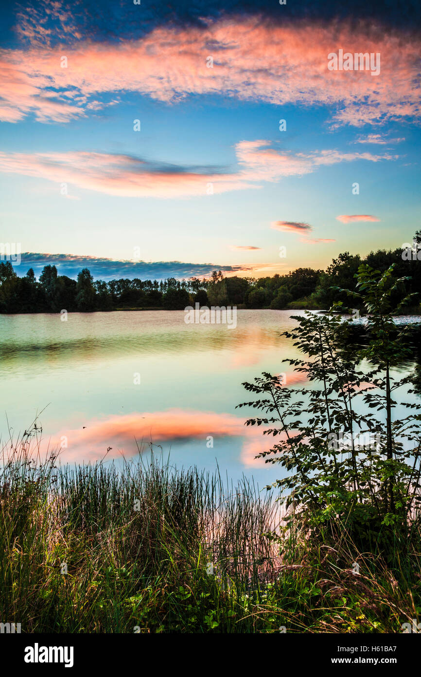 Tarda estate sunrise su uno dei laghi a Cotswold Water Park Foto Stock