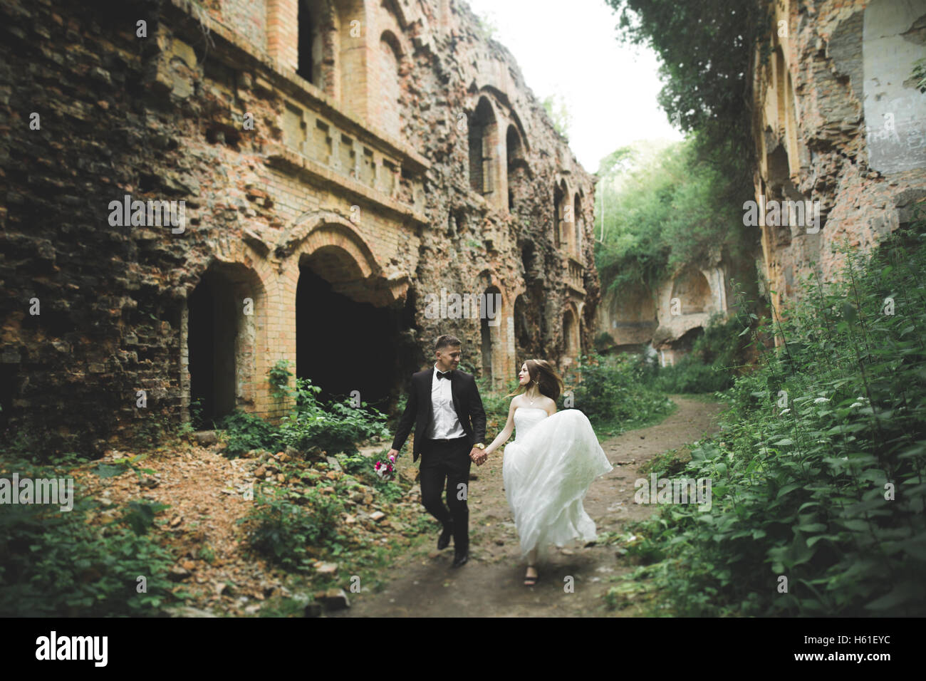 Happy sposi vicino all'antico castello sulla passeggiata Foto Stock