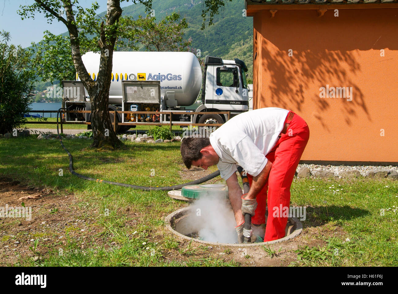 Melano, Svizzera -20 Maggio 2005: lavoratore rendendo la fornitura di gas su di un serbatoio nel giardino di una casa a Melano sulla Svizzera Foto Stock