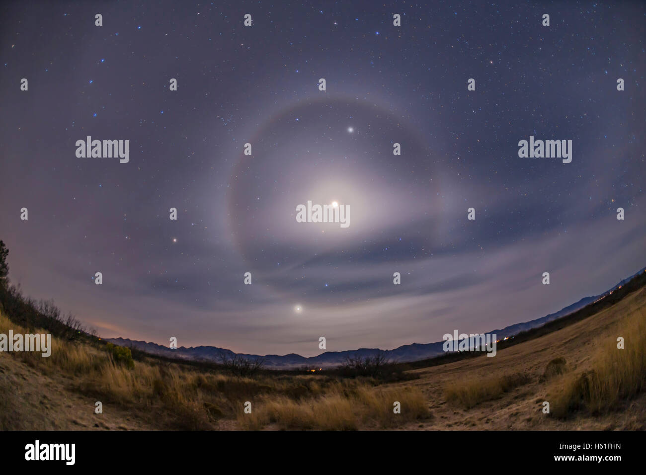 Un classico 22° cristallo di ghiaccio alone attorno al calante Crescent Moon, qui sovraesposte, con la luna tra Marte e Giove in Foto Stock