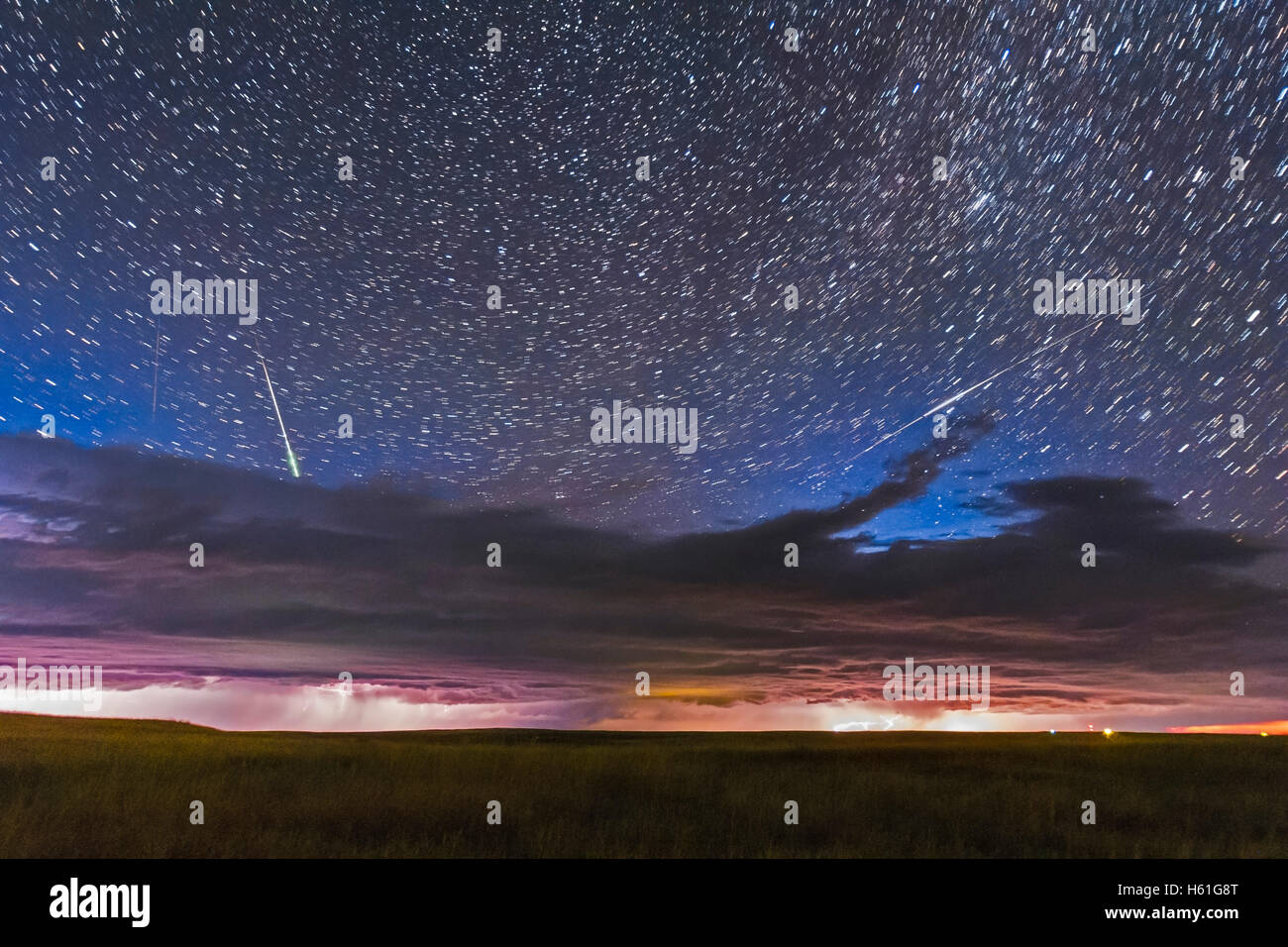Un cielo occupato - con una linea di temporali attraverso l'orizzonte settentrionale, le stelle circumpolare sopra di coda e un luminoso bolide soddisfatte Foto Stock