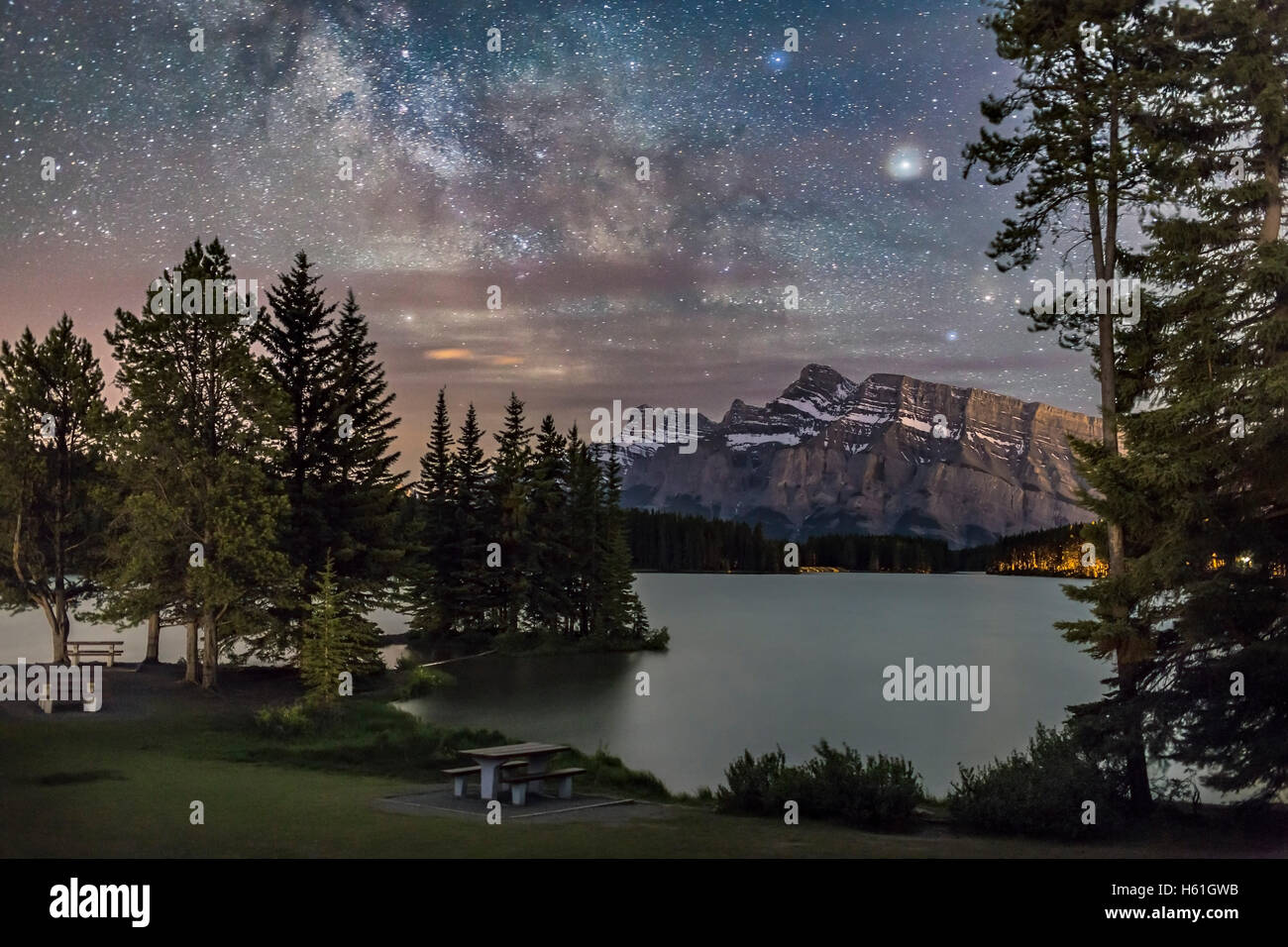 La Via Lattea nel Sagittario e Scorpione, bassa nel sud, su Mt. Rundle in Banff, Alberta, dalla riva di due martinetti a lago, Foto Stock