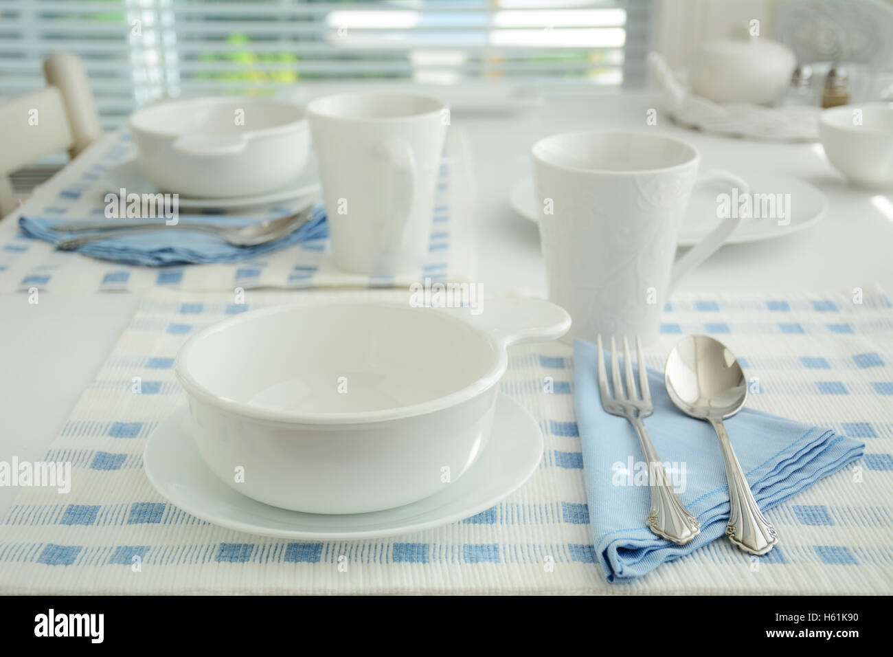 Blu e bianco creare una semplice tabella elegante impostazione. Estremamente leggera profondità di campo a. Colpo di luce naturale. Foto Stock