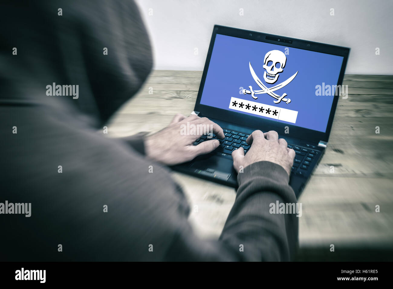 Vista posteriore di un hacker che indossa una felpa con cappuccio e rubare una password su uno schermo di computer portatile Foto Stock