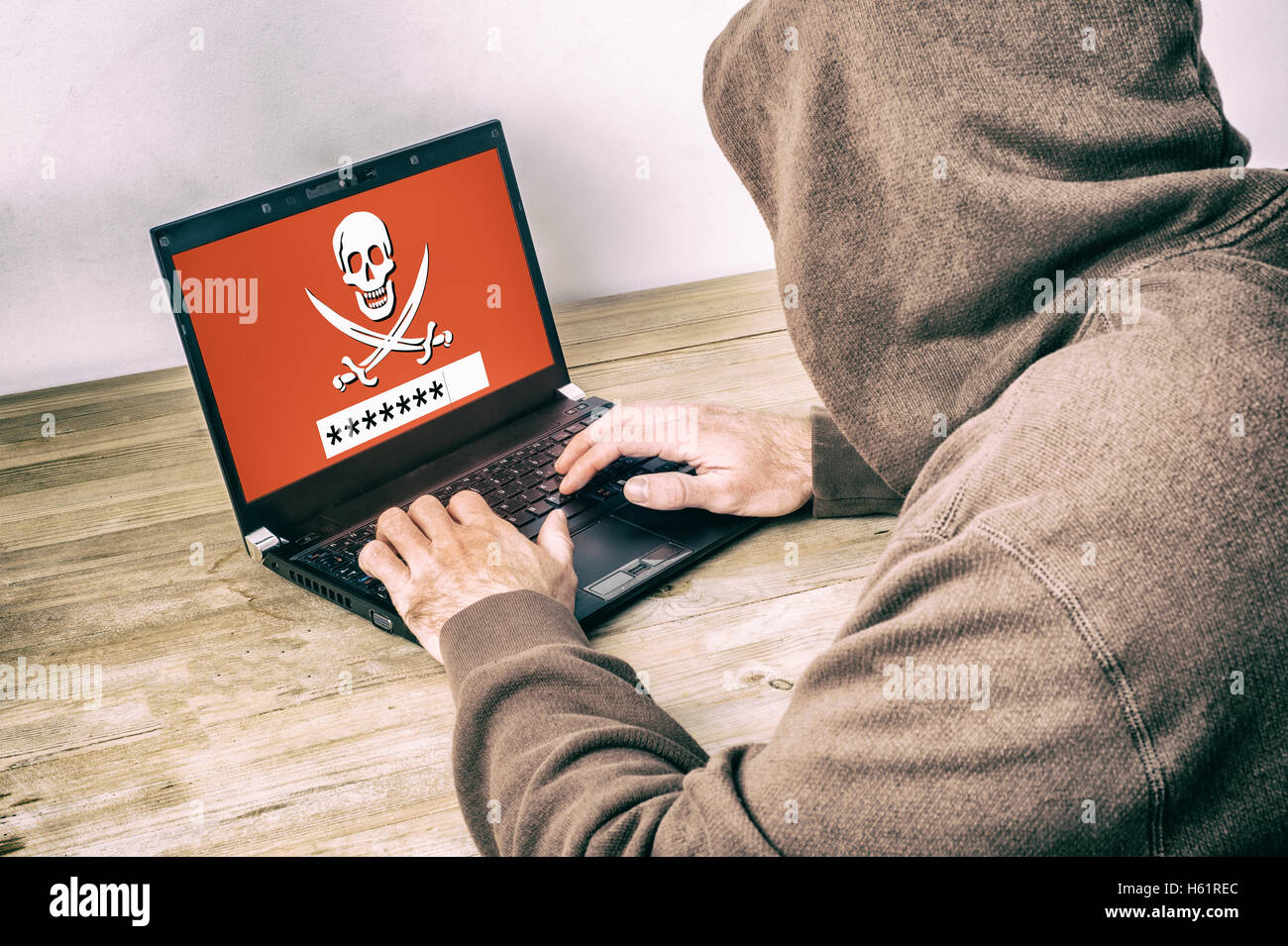 Vista posteriore di un hacker che indossa una felpa con cappuccio e rubare una password su uno schermo di computer portatile Foto Stock