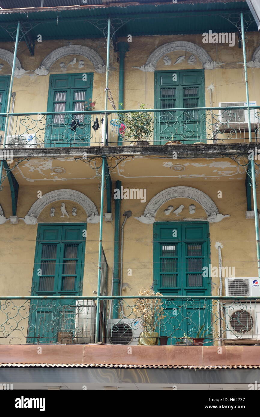 Macao Cina balconi vicino al vecchio centro di motivi di uccelli su porte domestiche balconi di ferro stucco color crema verde tradizionale verniciatura Foto Stock